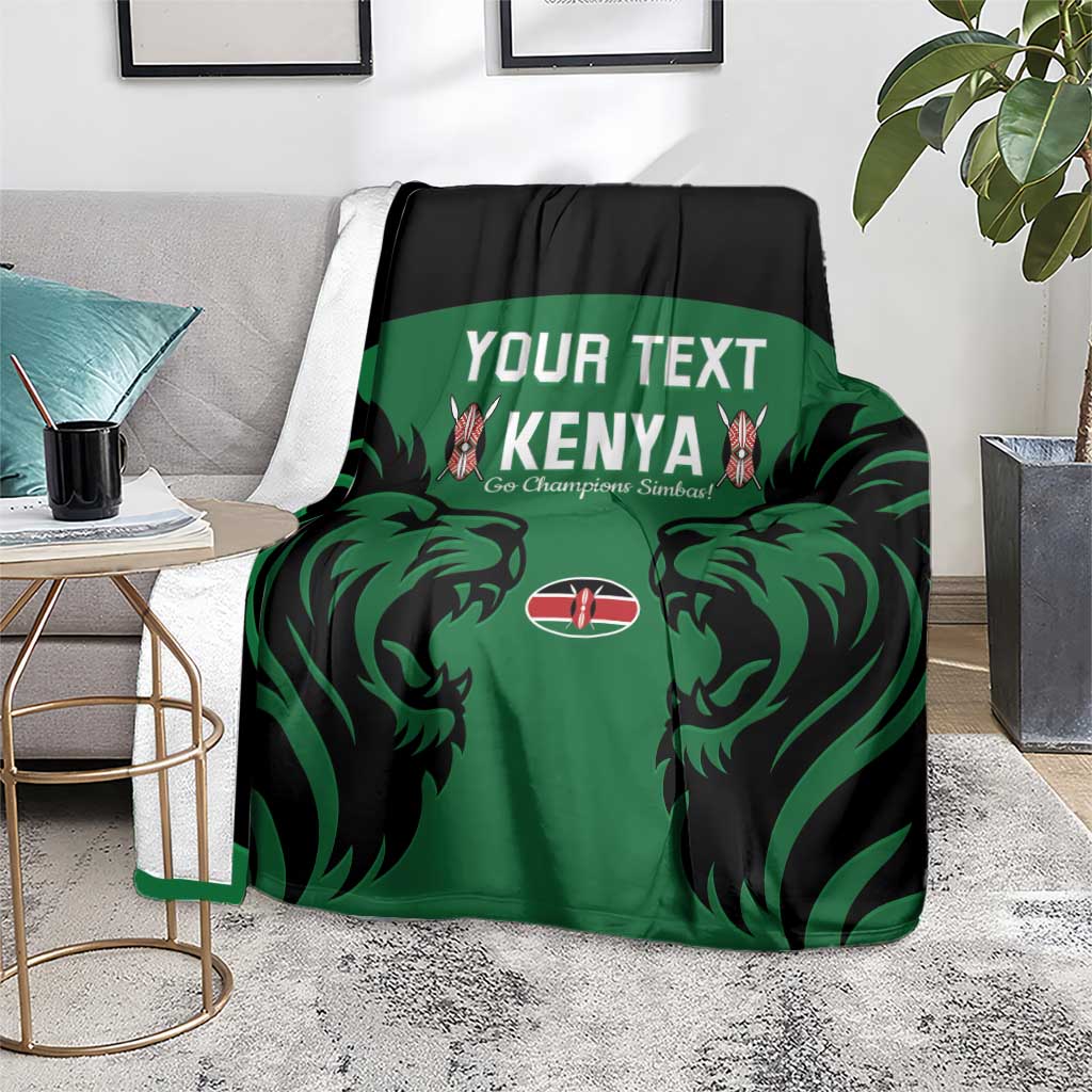 Green Kenya rugby blanket with black trim, lion graphic and Kenya text, on couch