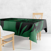 Green and black leaf-pattern tablecloth with overhanging corner on a bench table