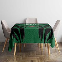 Green and black leaf-pattern tablecloth on a small dining table with chairs