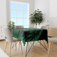 Green and black rugby-style tablecloth with bold leaf pattern, draped on a table