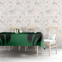 Green and black leaf-pattern tablecloth covering a dining table