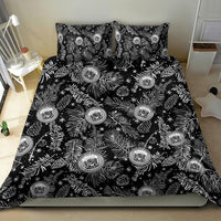 Black bedding set spread out with white pine/leaf motif and round crest emblems