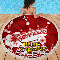 Red round beach blanket with white tropical and geometric design, tassel fringe edge