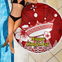 Red round beach blanket with white floral and geometric artwork, tassel fringe edge
