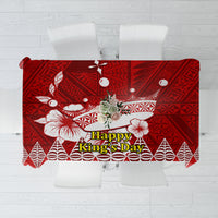 Red tablecloth with white Tongan-style geometric and floral motifs, centered text panel