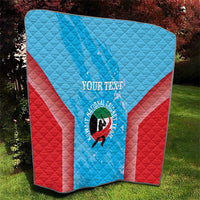 Cricket quilt laid flat with light blue center panel, red sides, custom text and logo