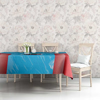 Cricket-themed tablecloth in blue with red hem, laid on a dining table with chairs