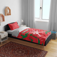 Red duvet with green flag waves and crossed swords emblem, paired with two matching pillowcases.