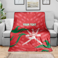 Red custom cricket blanket draped on sofa with green stripes and crossed swords emblem