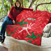 Red quilt blanket with green wave pattern and white emblem, custom text across