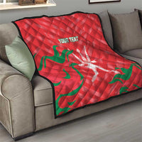 Red quilt blanket with green wave pattern and white emblem, custom text on sofa