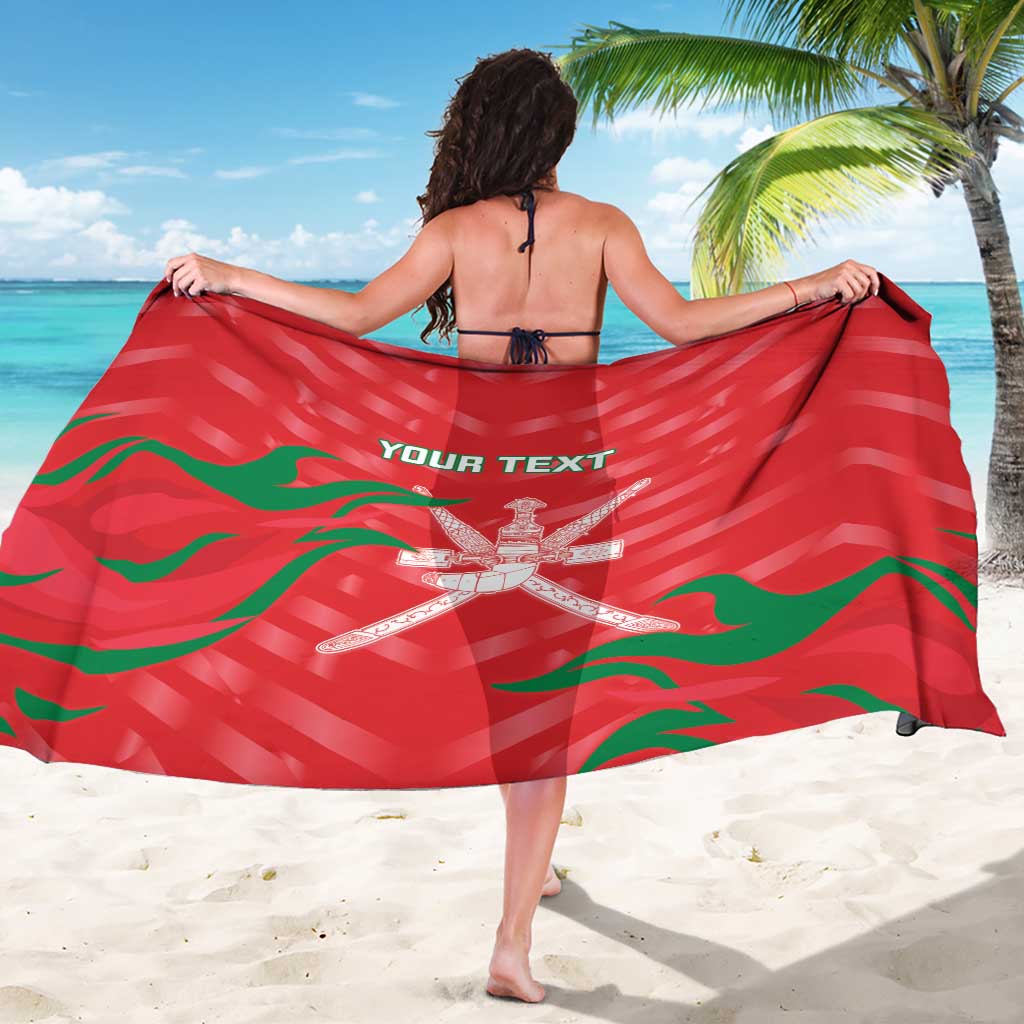 Red cricket sarong with green waves and white emblem, draped across back