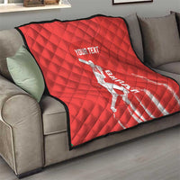Red diamond-quilted cricket blanket on a sofa, black edge, white batsman graphic and 'YOUR TEXT'.
