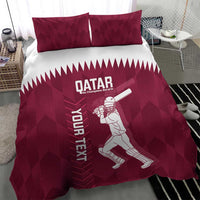 Maroon duvet cover and two pillowcases with Qatar logo, cricket player, and zigzag band