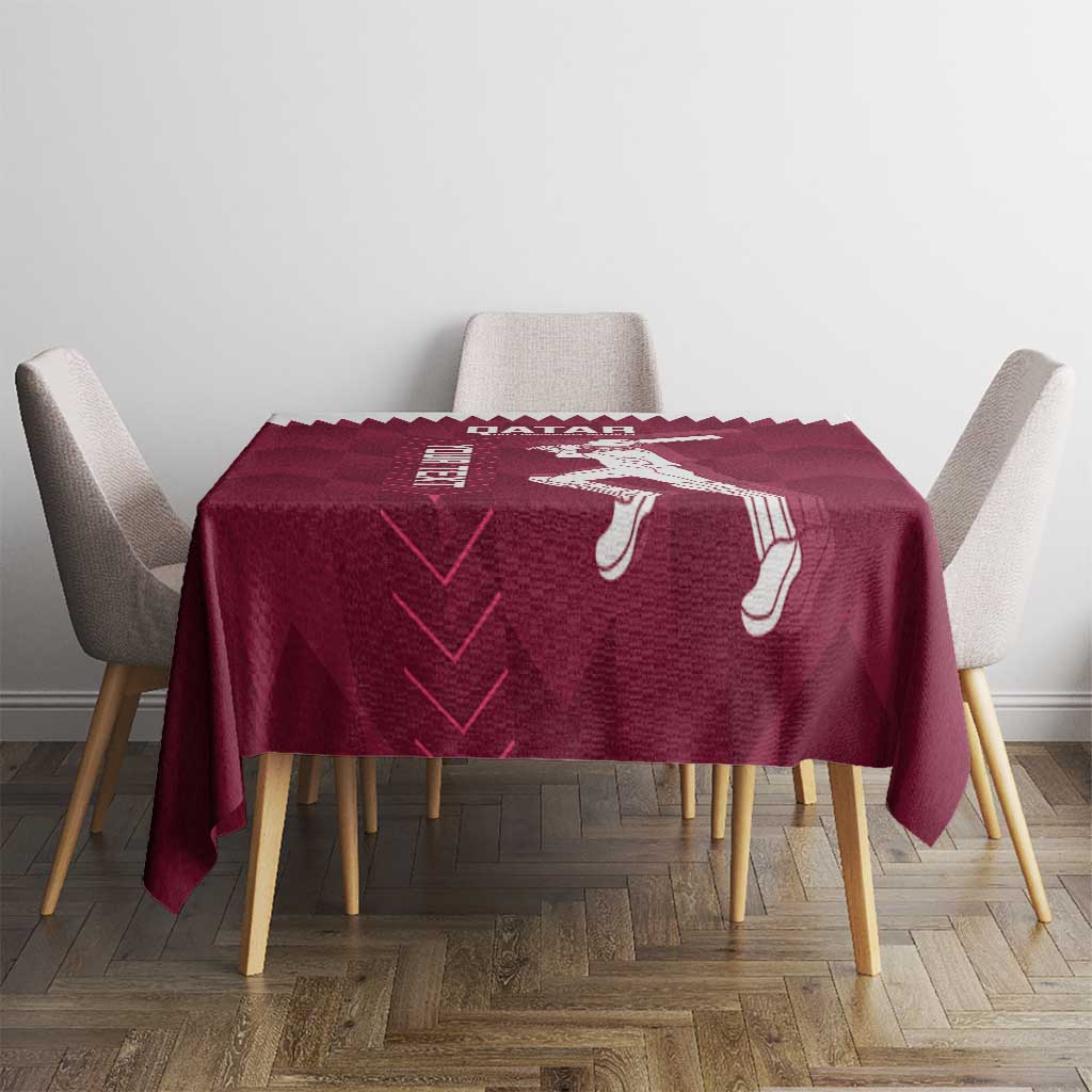 Maroon Qatar cricket tablecloth with white player icons and pattern, on dining table between chairs.