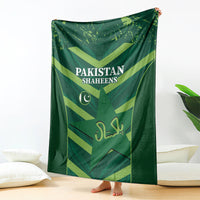Green Pakistan Shaheens blanket hanging on the wall, showing logo and team lettering