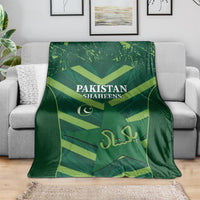 Green Pakistan Shaheens blanket spread on sofa, with logo and centered lettering
