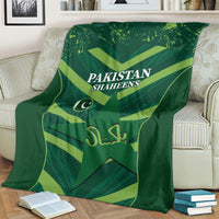 Green Pakistan Shaheens blanket on sofa, featuring logo and team lettering