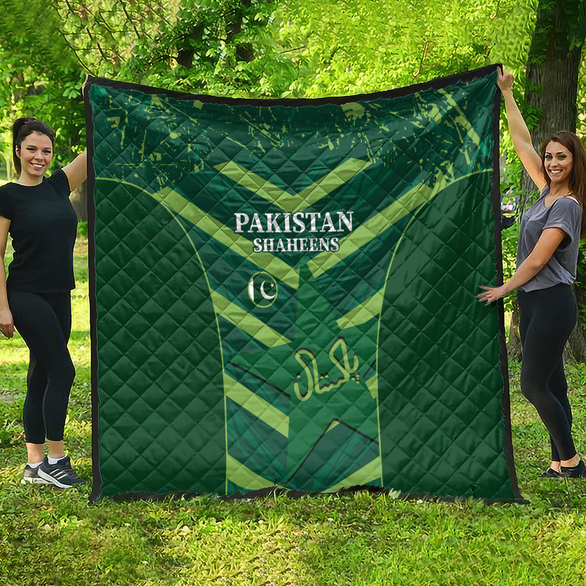 Green Pakistan Shaheens quilt hanging outdoors on grass