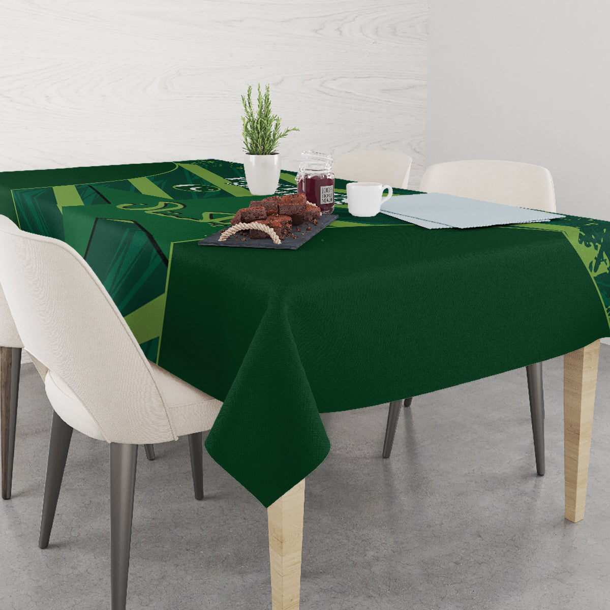 Green tablecloth on dining table with geometric border and centered graphic