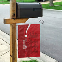 Red England cricket garden flag hanging vertically from a wooden fence post