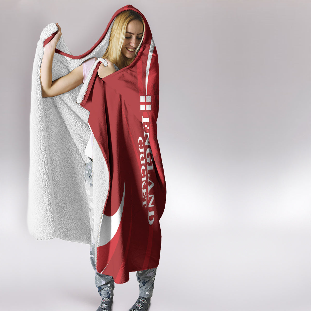 Red hooded blanket with white trim, draped over a person’s shoulders