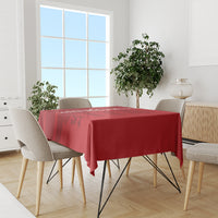 Red cricket-themed tablecloth on dining table with chairs and small centerpiece