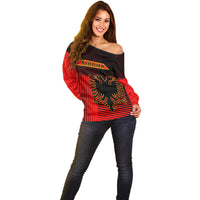 Red and black off-shoulder sweater with front crest graphic and long sleeves
