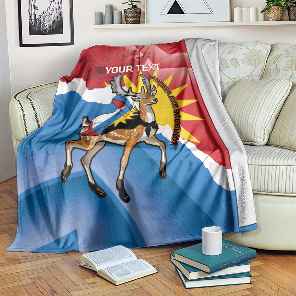 Red and blue blanket with deer illustration, 'YOUR TEXT' wording, and Antigua and Barbuda emblem