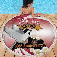 Round beach blanket on wooden deck, red-pink Latvia bird graphic with daisies