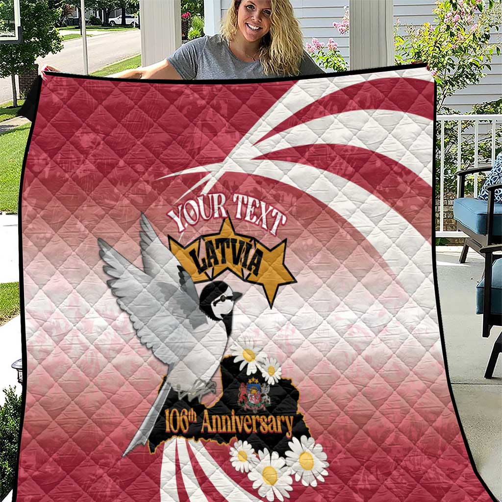 Red quilt with Latvian flag ring, eagle and daisies; “Your Text” and 106th Anniversary