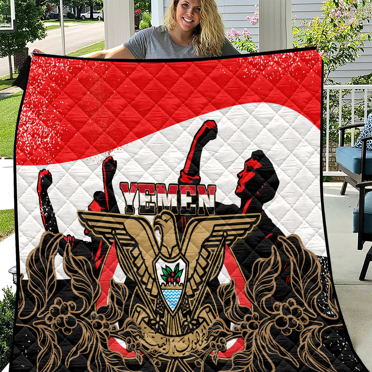 Red, white, and black quilt with Yemen emblem, rifles, and gold ornate pattern