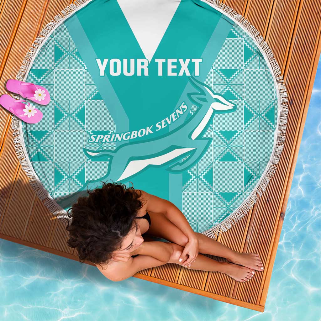 Close-up of round teal blanket with white fringe, centered “YOUR TEXT” and Springbok Sevens logo.