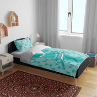 Teal patterned bedding set with duvet and two pillows on a bed with headboard