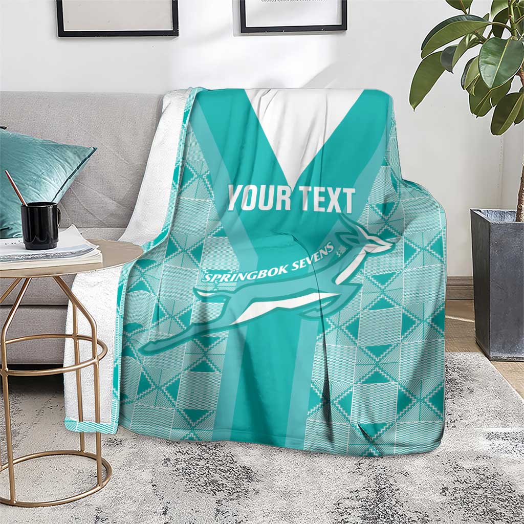 Teal custom rugby blanket on floor with white V stripe, Springbok graphic and "YOUR TEXT"