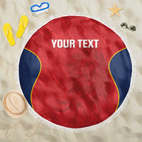 Red round beach blanket with white fringe, blue-and-yellow curved borders, 'YOUR TEXT' print