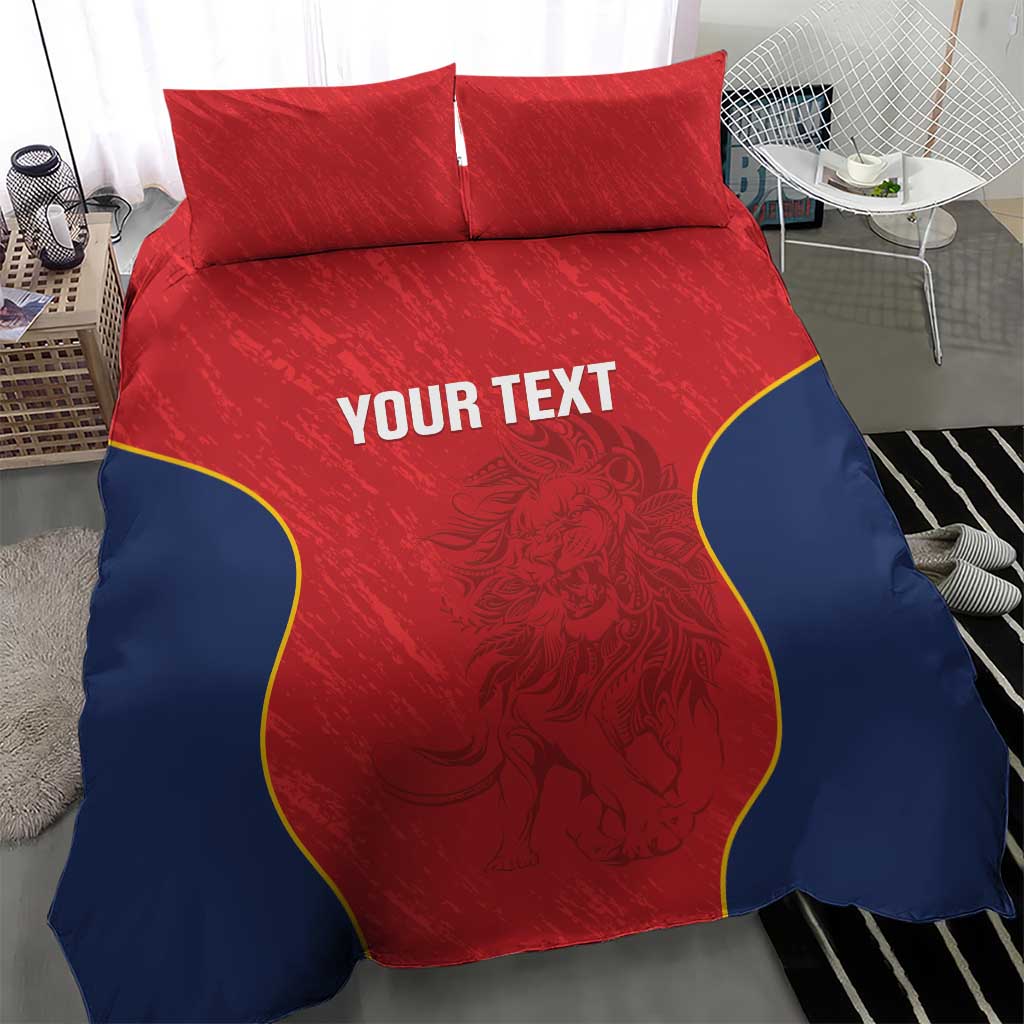 Red and navy bedding set with two pillows and yellow-edged curved design, “YOUR TEXT” center