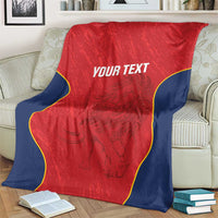 Red Spain rugby blanket on couch, navy border and yellow edging with “YOUR TEXT”.