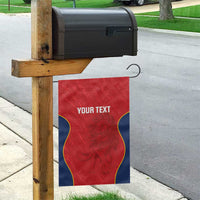 Custom red rugby garden flag hanging on wooden post, blue wavy trim, 'YOUR TEXT' and lion art