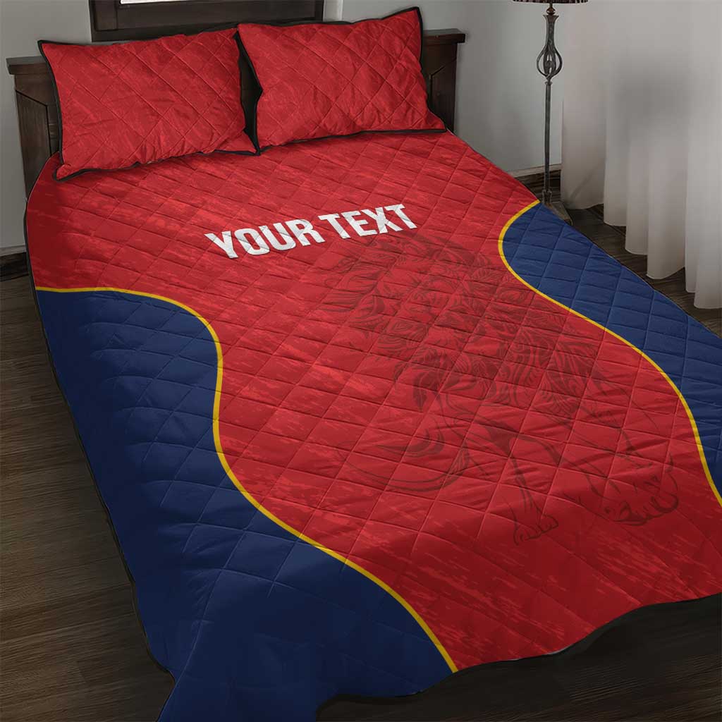 Red quilt bed cover with blue sides and yellow outline, quilted texture and centered text