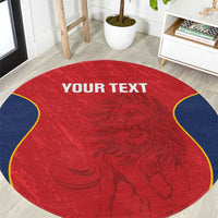 Round red rug with navy scalloped edge, ornate crest pattern, "YOUR TEXT" centered