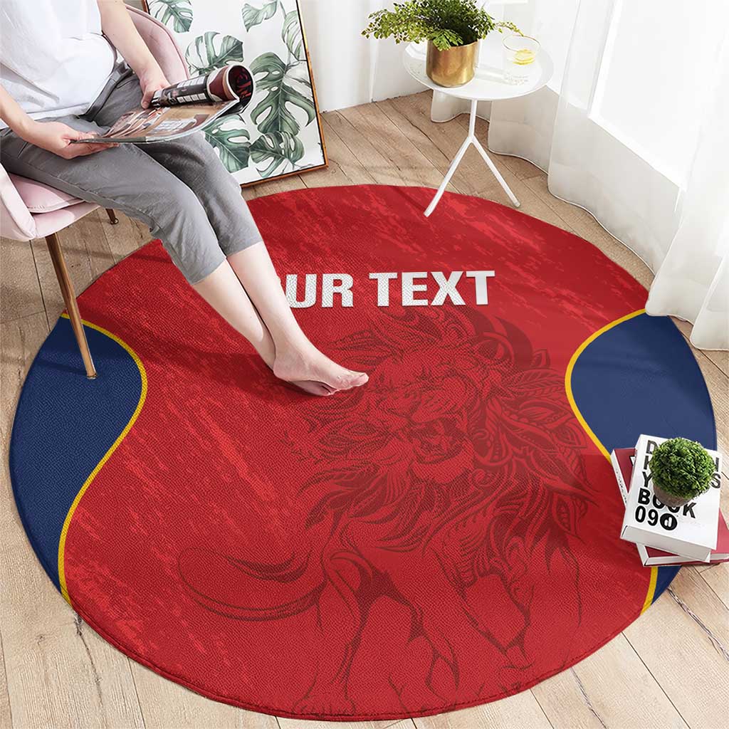 Round red rug with navy border and ornate crest pattern, "YOUR TEXT" across center