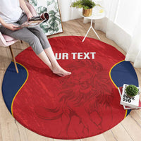 Round red rug with navy border and ornate crest pattern, "YOUR TEXT" across center