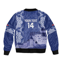 Blue bomber jacket back with white ornaments, castle graphic, and "YOUR TEXT" 14