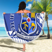 Personalized round blue beach blanket with white pattern, crest emblem, and fringed border
