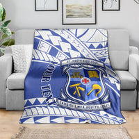 Blue and white St Joseph's College crest throw blanket draped over a gray sofa