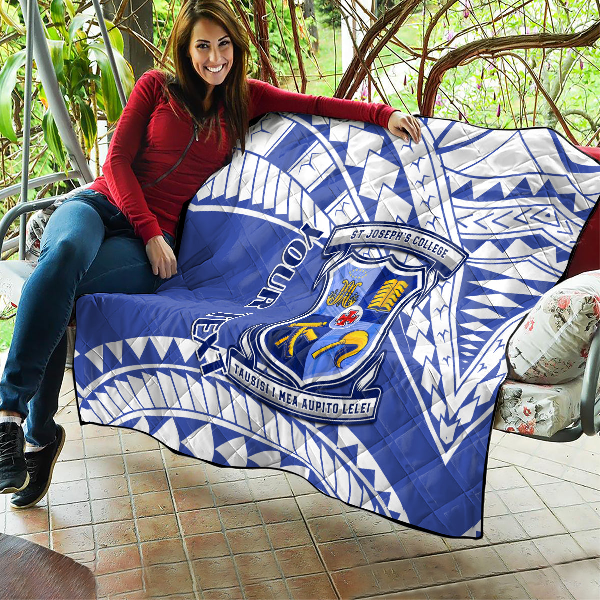 Blue quilt draped on couch with white geometric pattern and St Joseph’s College crest