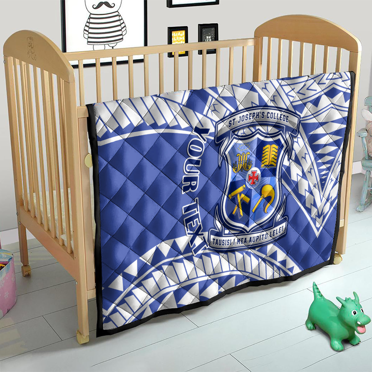 Blue quilt with white geometric pattern and St Joseph’s College crest on a toddler bed