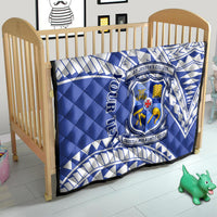 Blue quilt with white geometric pattern and St Joseph’s College crest on a toddler bed