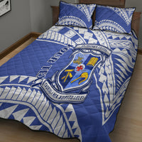 Blue and white quilt bed set with central school crest and geometric triangle pattern